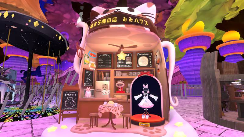 Cloud Star Cafe’s cat-shaped booth, in a halloween-like background. A table for two is at the front, with a pink costume on display beside it.