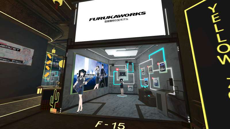 Booth of FurukaWorks. Its banner is a black logo on white background. Various props are displayed inside.