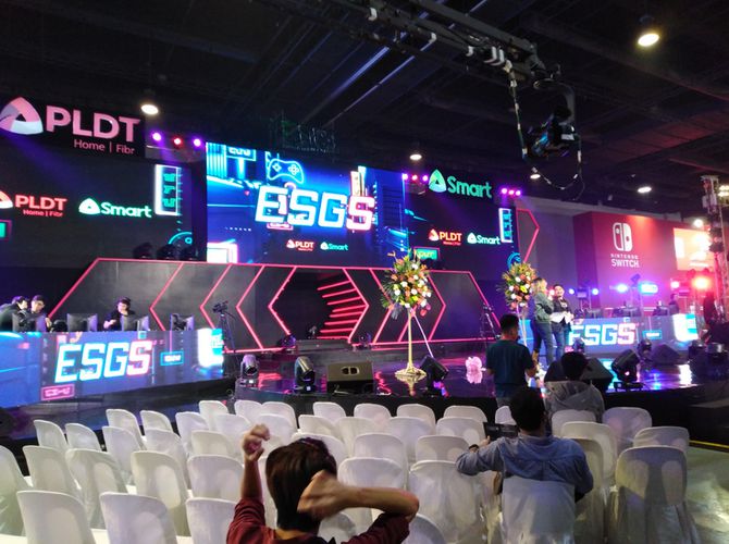 ESGS event stage with neon lights and a few people watching the hosts at the front…