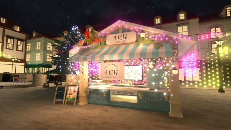 A food stand with a mint and white color scheme, decorated with Christmas lights. Assortments of fruits on plates are displayed on the front, alongside a sign that says “Kyobashi Sembikiya, Tokyo 1881”.
