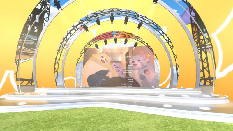 Event stage. Three yellow circles form a tunnel-like shape, with a screen in the center. A music video is shown.