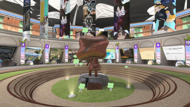 Various world instances are being showcased, with a cute blob-faced smiling mascot statue in the center. More of the mascots with green faces are doing poses around it.