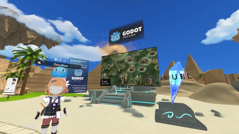 Godot Engine booth, playing a trailer of various games. A 3D avatar wearing an Atelier costume is standing beside it.