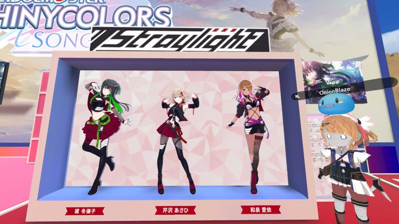 Booth for Idolmaster Shiny Colors: Song for Prism. A 3D avatar with an Atelier costume is posing in front of a display of Straylight members.